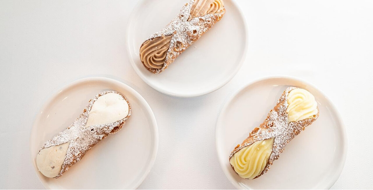 Filled cannoli pastries and dusted with powdered sugar.